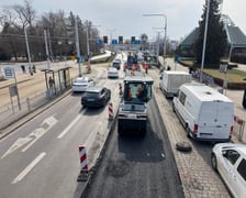 Układanie masy bitumicznej na ulicy Powstańców Śląskich między Orlą a Krzycką