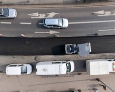 Układanie masy bitumicznej na ulicy Powstańców Śląskich między Orlą a Krzycką