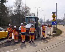 Układanie masy bitumicznej na ulicy Powstańców Śląskich między Orlą a Krzycką