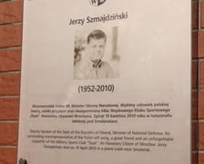 <p>Składanie kwiat&oacute;w pod tablicą Jerzego Szmajdzińskiego</p>
