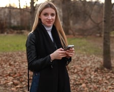 Kobieta z telefonem podczas spaceru w Parku Staromiejskim