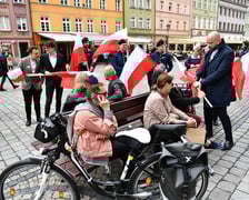 Prezydent Wrocławia Jacek Sutryk rozdaje flagi mieszkańcom i turystom.