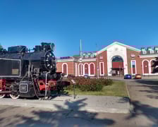 <p>Zabytkowa lokomotywa i w tle dworzec kolejowy w Kramatorsku</p>
