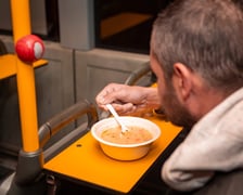 <p>Mężczyzna jedzący zupę w Streetbusie</p>