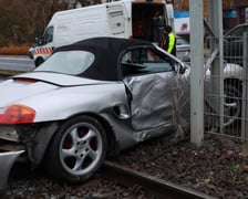 na zdjęciu samochód porsche, który wjechał pod tramwaj na torowisku