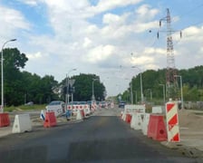 Na ul. Kosmonautów trwają prace budowlane, robotnicy układają masę bitumiczną.