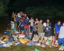 Kobiety i mężczyźni podczas akcji  na wale Janówek - Pracze. Trwa jego uszczelnianie