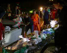 Kobiety i mężczyźni podczas akcji  na wale Janówek - Pracze. Trwa jego uszczelnianie