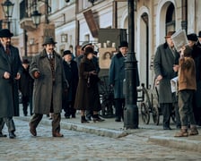 Kadr z filmu "Znachor" Netflixu. Na zdjęciu od lewej Leszek Lichota, Mirosław Haniszewski, w tle grupa statystów