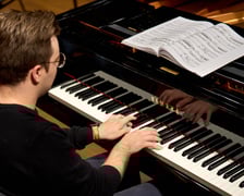 <p>Piotr Alexewicz podczas pr&oacute;by w sali czerwonej Narodowego Forum Muzyki</p>