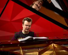 <p>Piotr Alexewicz podczas pr&oacute;by w sali czerwonej Narodowego Forum Muzyki</p>