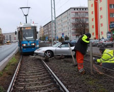 na zdjęciu samochód porsche, który wjechał pod tramwaj na torowisku
