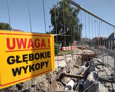 Głębokie wykopy w drodze rowerowej i plac budowy obok