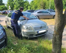 Źle zaparkowane samochody. Strażnik miejski zostawia informację o mandacie