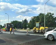 Na ul. Kosmonautów trwają prace budowlane, robotnicy układają masę bitumiczną.