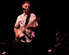 Na zdjęciu grający na gitarze Tomek Lipiński