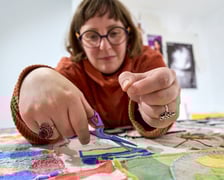 <p>Olga Budzan przy zszywaniu tkaniny artystycznej w Barbarze</p>