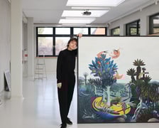 <p>Modesta Gorol przy swoim obrazie podczas przygotowań do wystawy w CK Agora</p>