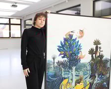 <p>Modesta Gorol przy swoim obrazie podczas przygotowań do wystawy w CK Agora</p>