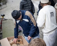 <p>mężczyzna zaglądający do kartonu z produktami spożywczymi</p>