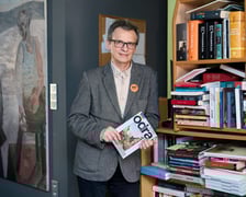 <p>Mariusz Urbanek w redakcji miesięcznika &bdquo;Odra&rdquo;, w tle obraz Edwarda Dwurnika&nbsp;</p>