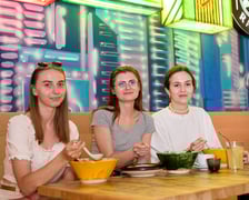 <p>Trzy młode, uśmiechnięta klientki Vegan AF Ramen przy stoliku, na kt&oacute;rym stoją miski z ramenem</p>