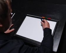 <p>Z wizytą w Niewidzialnym Domu we Wrocławiu. Na zdjęciu mężczyzna z kredką nad kartką papieru.</p>