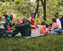 <p>Grupka os&oacute;b na kocu piknikowym w plenerze. Wiele projekt&oacute;w w Mikrgrantach zachęca do wyjścia na zewnątrz i spędzenia czasu na dworze.</p>