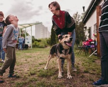 Uśmiechnięta kobieta i chłopiec stojący z psem podczas zajęć z gotowania