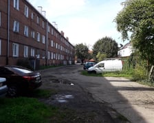 Podwórko przy Hallera przed rewitalizacją - widok na zdegradowaną nawierzchnię drogi wewnętrznej