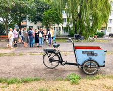 Uczestnicy oraz prowadzący podczas spotkań konsultacyjnych na podwórkach. Widoczny jest też, specjalnie oznaczony rower cargo będący mobilnym punktem konsultacji.