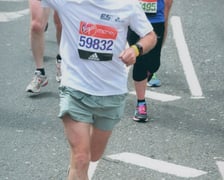 Biegnący zawodnicy podczas maratonu. Zbliżają się do mety, unoszą ręce w geście zwycięstwa. Na pierwszym planie starszy mężczyzna, prof. Jan Chmura, na drugim planie  młoda kobieta.