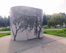 Toaleta w parku Jedności z jasną mozaiką, na której widzimy ciemne kontury drzew