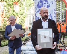 Pamiątkowy papier czerpany z wyciętego kasztanowca, otrzymał go stojący na pierwszym planie zdjęcia Jacek Sutryk. prezydent Wrocławia