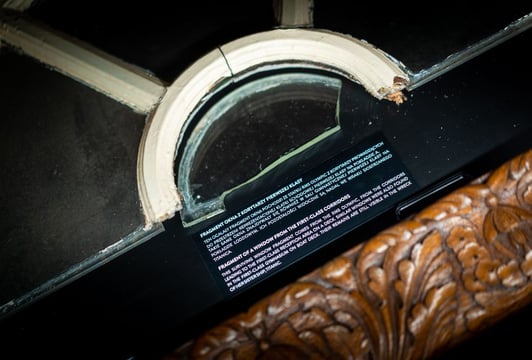 Fragment oryginalnego okna z pierwszej klasy jednego z liniowców, umieszczony w gablocie z opisem ekspozycyjnym.