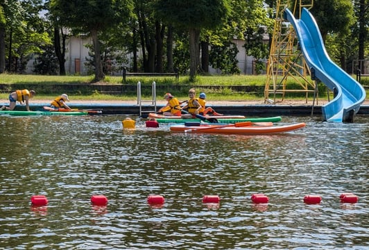 Dzieci na deskach SUP w Ośrodku Sportowo-Rekracyjnym w Wałach