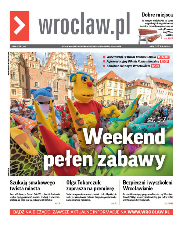 Zdjecie okładki biuletynu - Na wrocławskim Rynku stoi duża żółta maskotka w czerwonej koszulce z napisem "Kolejkowo" otoczona dziećmi z kolorowymi krasnalowymi czapkami na głowach