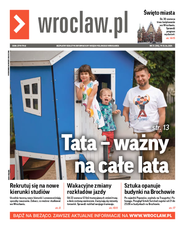 Zdjecie okładki biuletynu - Na tle niebieskiego domku  z placu zabaw tata Łukasz ze swoimi dziećmi: Zytą i Tymkiem
