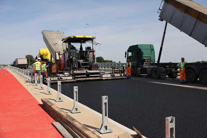 Robotnicy pracujący na wiadukcie, układają ostatnią warstwę nawierzchni