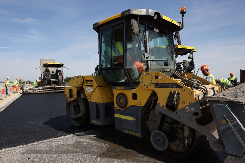 Robotnicy pracujący na wiadukcie, układają ostatnią warstwę nawierzchni