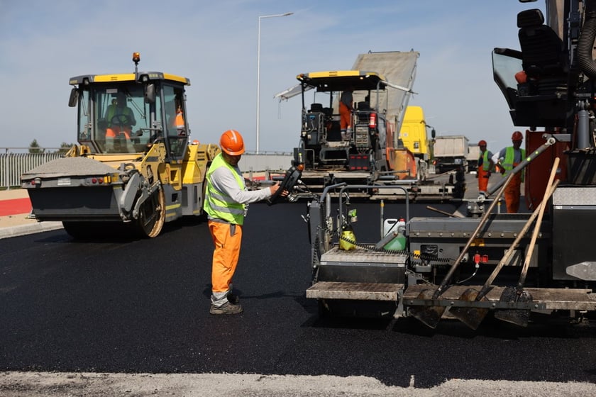 Robotnicy pracujący na wiadukcie, układają ostatnią warstwę nawierzchni