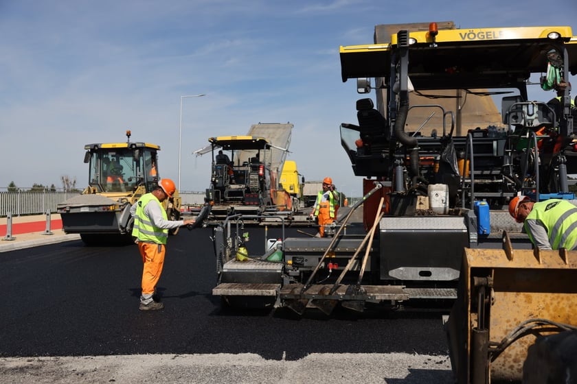 Robotnicy pracujący na wiadukcie, układają ostatnią warstwę nawierzchni