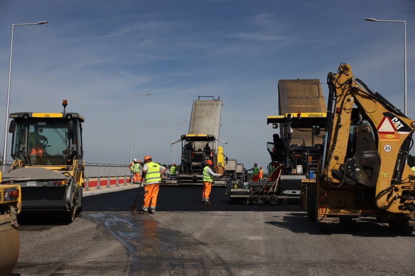 Robotnicy pracujący na wiadukcie, układają ostatnią warstwę nawierzchni