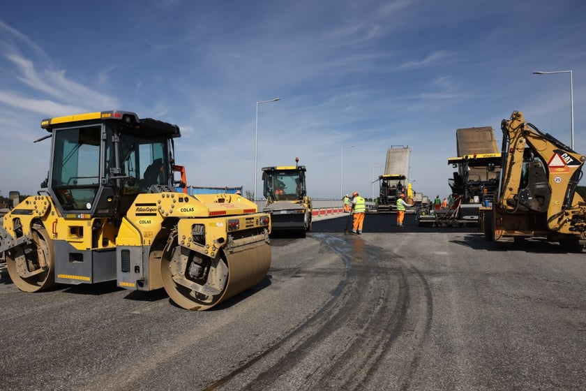 Robotnicy pracujący na wiadukcie, układają ostatnią warstwę nawierzchni