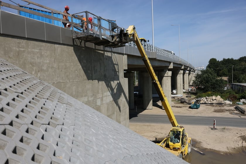 Robotnicy pracujący na wiadukcie, układają ostatnią warstwę nawierzchni