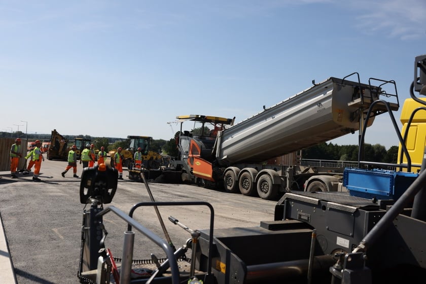 Robotnicy pracujący na wiadukcie, układają ostatnią warstwę nawierzchni