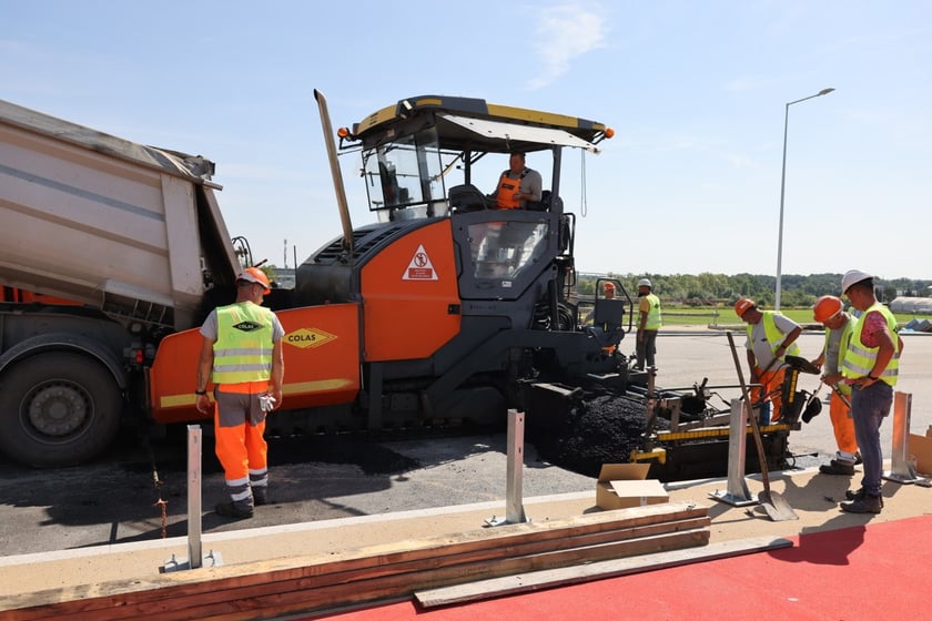 Robotnicy pracujący na wiadukcie, układają ostatnią warstwę nawierzchni