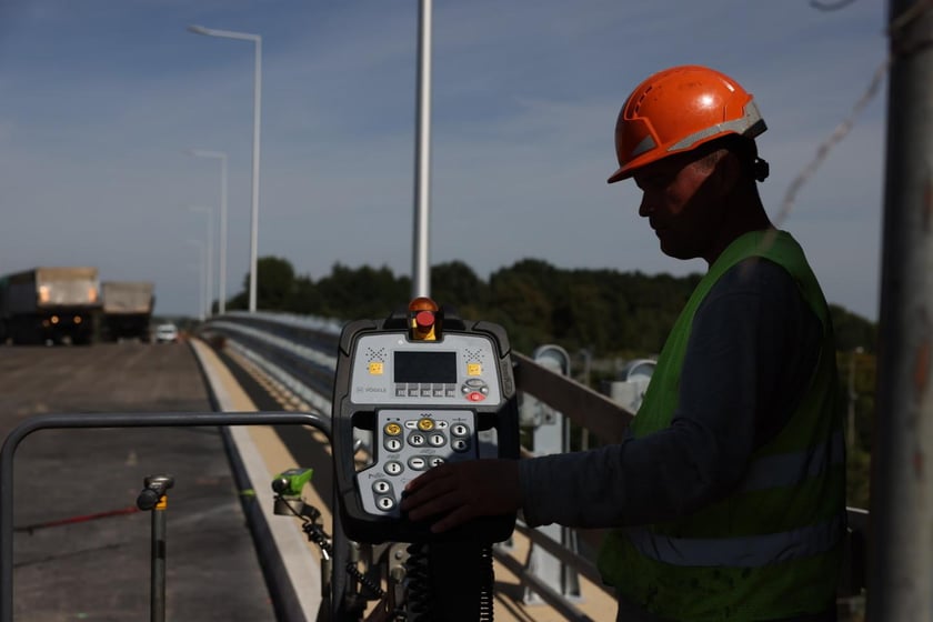 Robotnicy pracujący na wiadukcie, układają ostatnią warstwę nawierzchni