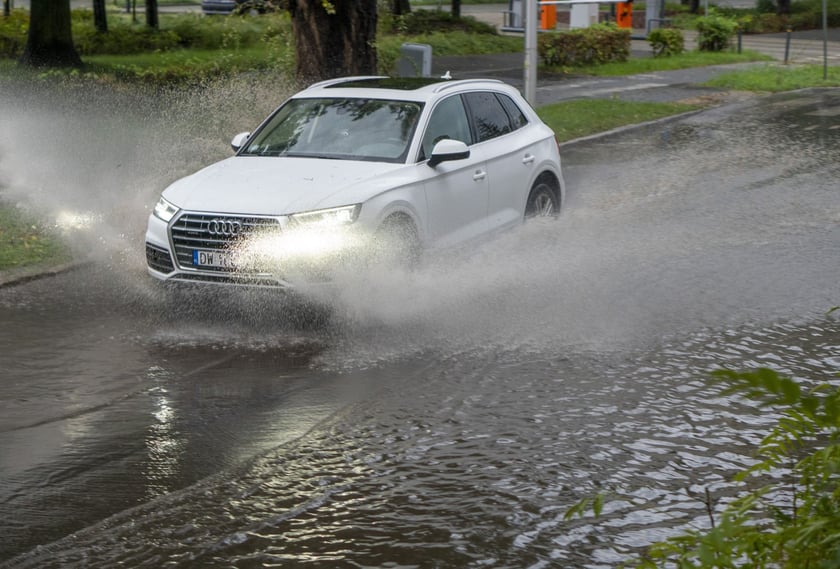 Samochód przejeżdża przez zalaną ulicę we Wrocławiu