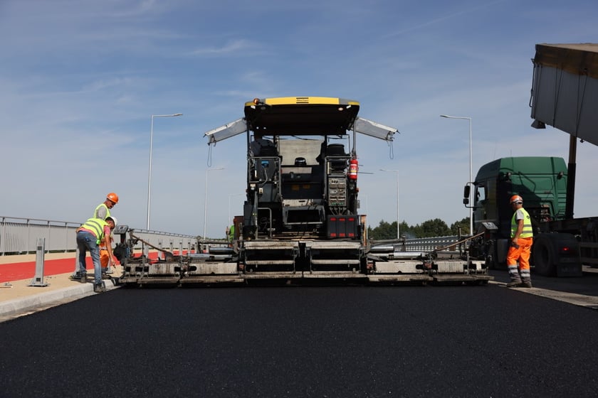 Robotnicy pracujący na wiadukcie, układają ostatnią warstwę nawierzchni